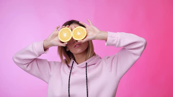 Woman in Casual Pink Clothes Holding Oranges and Dancing