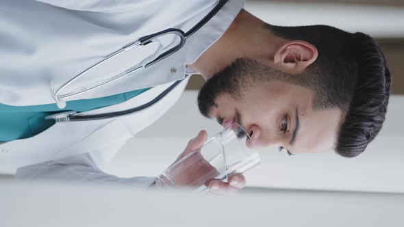 Vertical View of Young Man Thoughtful Arabian Doctor Wear White Medical Coat Looking Through Window alt