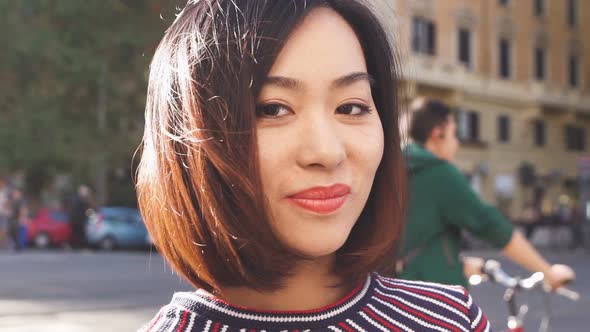 cute young chinese woman in the street smiling at the camera- slow motion alt