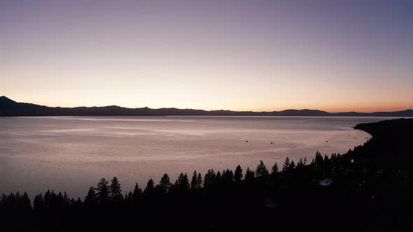 Wide aerial shot of the Lake Tahoe shoreline at twilight. 4K alt