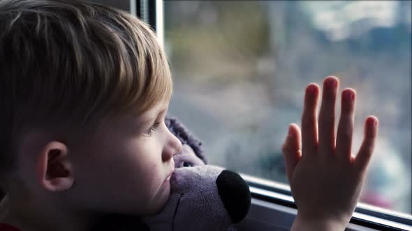 A Beautiful Little Blonde Boy Looking Out a Sunny Window Waiting on Her Daddy to Come Home from Work