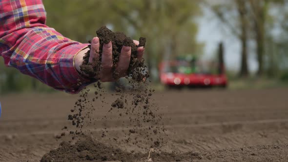 Close-up of Hand, Farmer, Agronomist Checks Quality of Soil on Farm Field. Background of Working alt