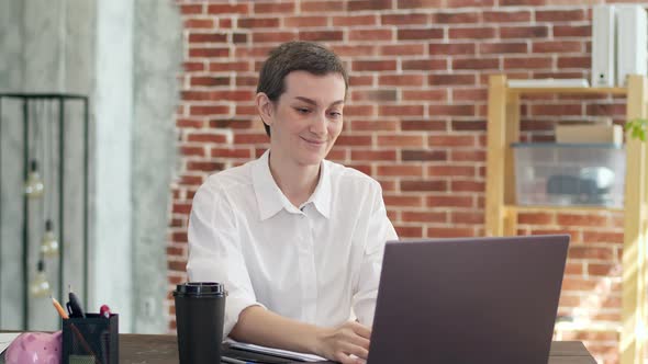 Businesswoman Works at a Laptop Sitting at Desk and Rejoices Gesticulating Hands Under Falling alt