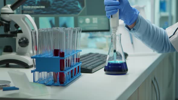 Close Up of Scientis Testing Liquid Sample Using Micropipette alt
