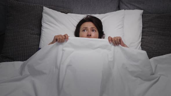 Scared Woman in Bed