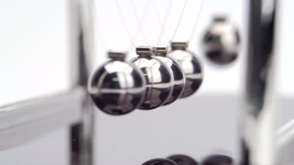 Newton's Cradle metal balls on white background, swinging metal balls. Close up