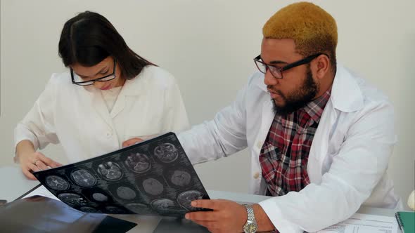 Medical Workers Discussing Brain Computed Tomography X-ray Image alt