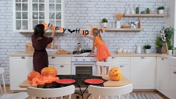Mother with Daughter Preparing for Halloween alt