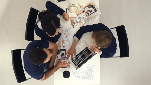 Young Couple on Consultation of a Designer, Looking Scetches on Laptop in the Office alt