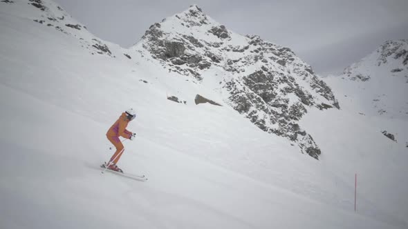 Sporty Woman Skiing Alone on Ski Slope in Winter Mountains