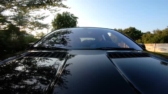 Young Couple Riding Through Countryside By Car with Sunset on Background alt