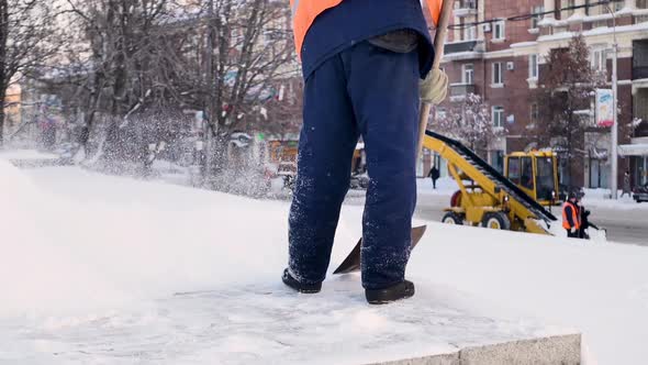 Workers Sweep Snow From Road in Winter Cleaning Road From Snow Storm