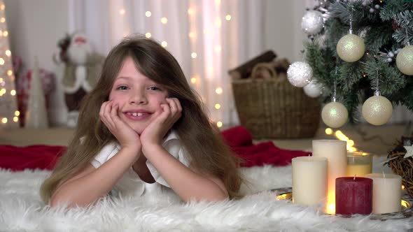 Christmas festive holiday tree scene with pretty girl looking at camera