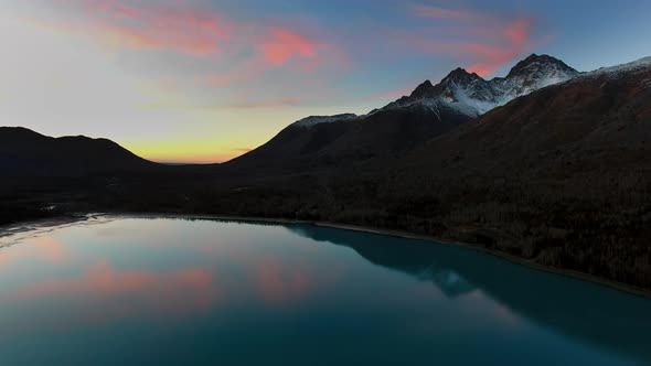 Aerial shot of a blue lake at sunset with amazing pink clouds (Eklutna Lake, Alaska, USA) alt