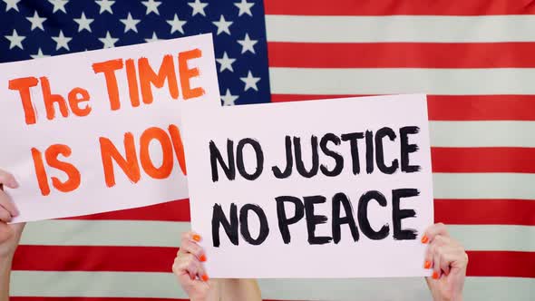 Protesters Hold Banners with Slogans - The Time Is Now. NO JUSTICE NO PEACE - Against Background of alt