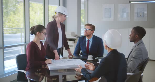 Team of Diverse Male and Female Engineers and Architects Discussing Construction Plans alt