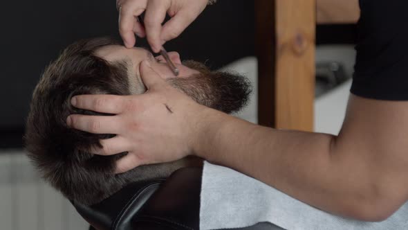 Barber Trimming Beard of Client