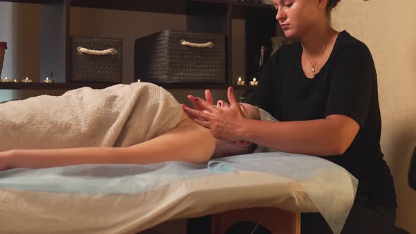 A Woman Enjoys a Facial Massage at a Beauty Clinic