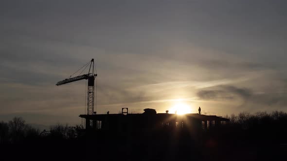 Construction site with big tower crane in time lapse with cloudscape. alt