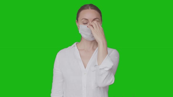 Woman Takes Off Medical Mask and Smiles Standing Against the Background of the Chromakey alt