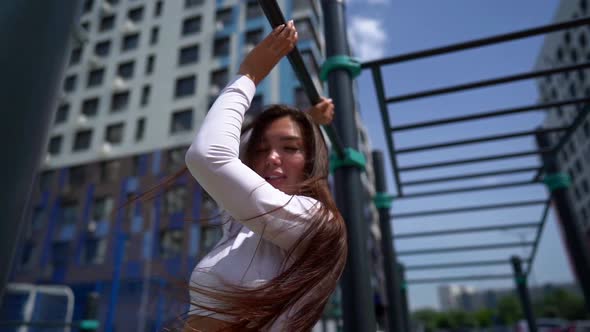 Sensual Woman Slender in a Top and Thong Posing on an Outdoor Sports Field, Touching the Crossbars alt