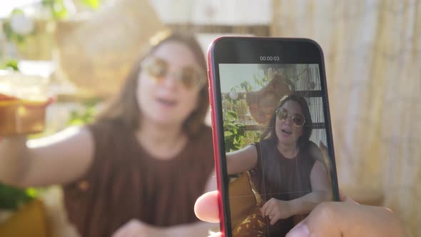 Positive Lady in Glasses Shows Cocktail Posing for Camera