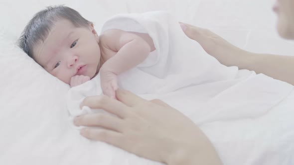 Mother take care her adorable newborn baby carefully with love. alt