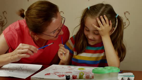 A Grown Woman Teaches a Little Girl the Art of Drawing