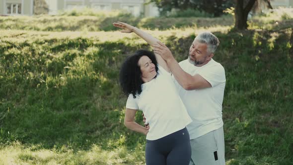 Middle Aged Man and Woman Doing Morning Exercises alt
