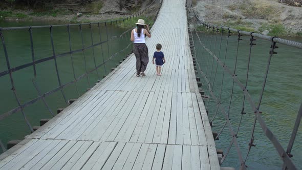 Mother And Child Crosses The Suspension Bridge