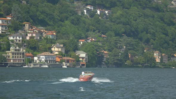 Traveling on a boat in near a luxury resort town on Lake Como, Italy, Europe. alt