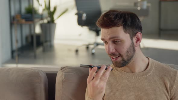 Happy guy recording an audio message on the phone alt