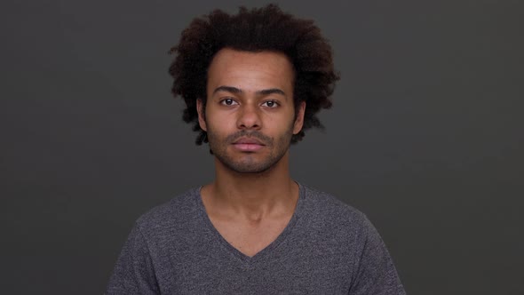 Young Darkskinned Male with Afro Haircut Cheerfully Nodding Isolated Over Charcoal Background alt