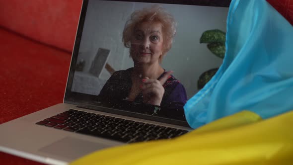 Laptop with Video Conference and Presentation Near the Flag of Ukraine