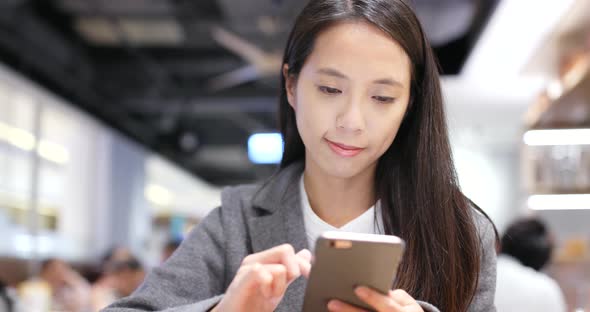 Woman read on cellphone in restaurant alt