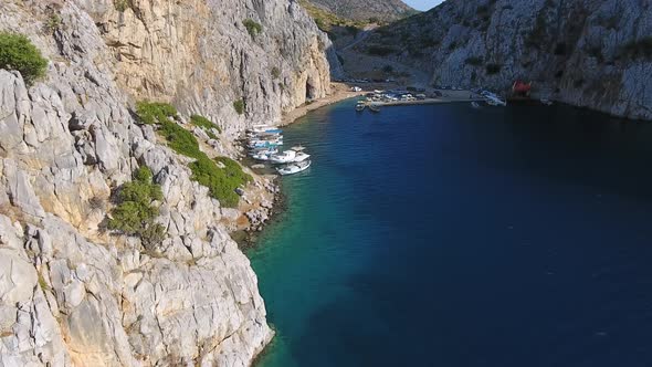 Small Fishing Harbor in a Narrow Valley Between Steep Walled Rocky Mountains alt
