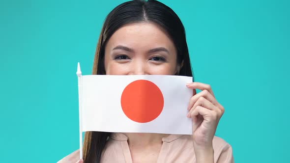 Woman Covering Mouth by Japanese Flag, Foreign Language School, Tourism alt