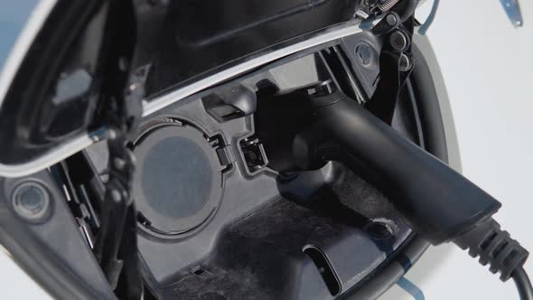 Electric Car Charging Batteries with Electricity Through Power Cable on Parking Lot alt