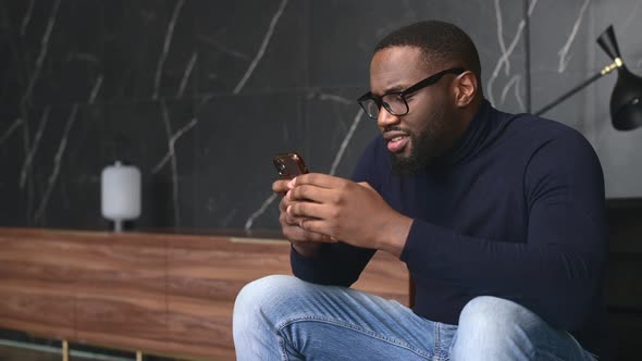 Hilarious AfricanAmerican Man Chatting on the Smartphone alt