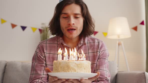 Close Up Portrait of Birthday Man Blowing Candles on Holiday Cake Slow Motion alt