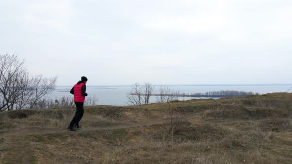Aerial view drone Athletic man in red west running in the nature alt