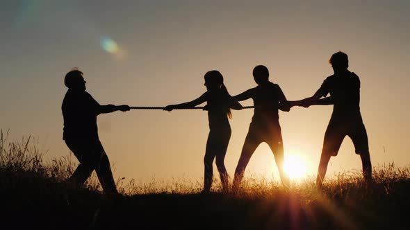 A Strong Older Woman Is Competing with Young People in Tug-of-war. Active Senior People alt