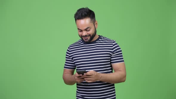Young Happy Bearded Indian Man Using Phone