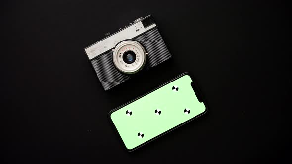 Old Retro Film Camera and Modern Smartphone on Black Background alt