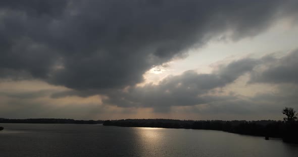 A Wide River Flowing Through The Forest And A Gloomy Sky Above It