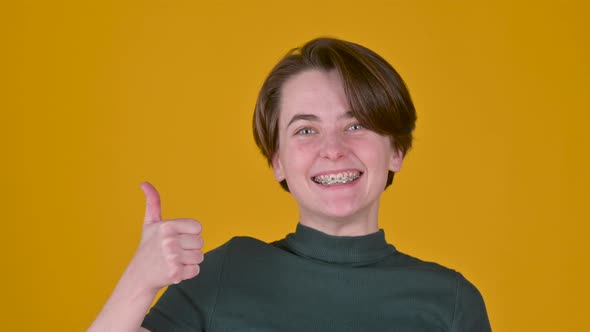 Positive young girl posing isolated on yellow studio background.