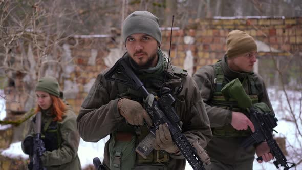Tactical Group Walking in Ruined City in Ukraine As Man Gesturing Stop Listening Looking Around alt