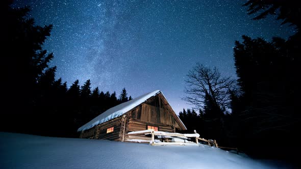 Time lapse. Beautiful wooden house in the winter forest under the stars