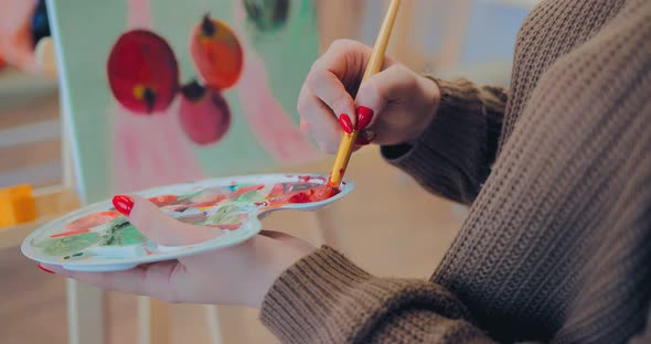 Artist Holds the Palette in His Hands and Draws a Picture with Apples