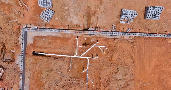 Installing Sewer and Water Pipes in the Ground Under the Foundation of a New Residential alt